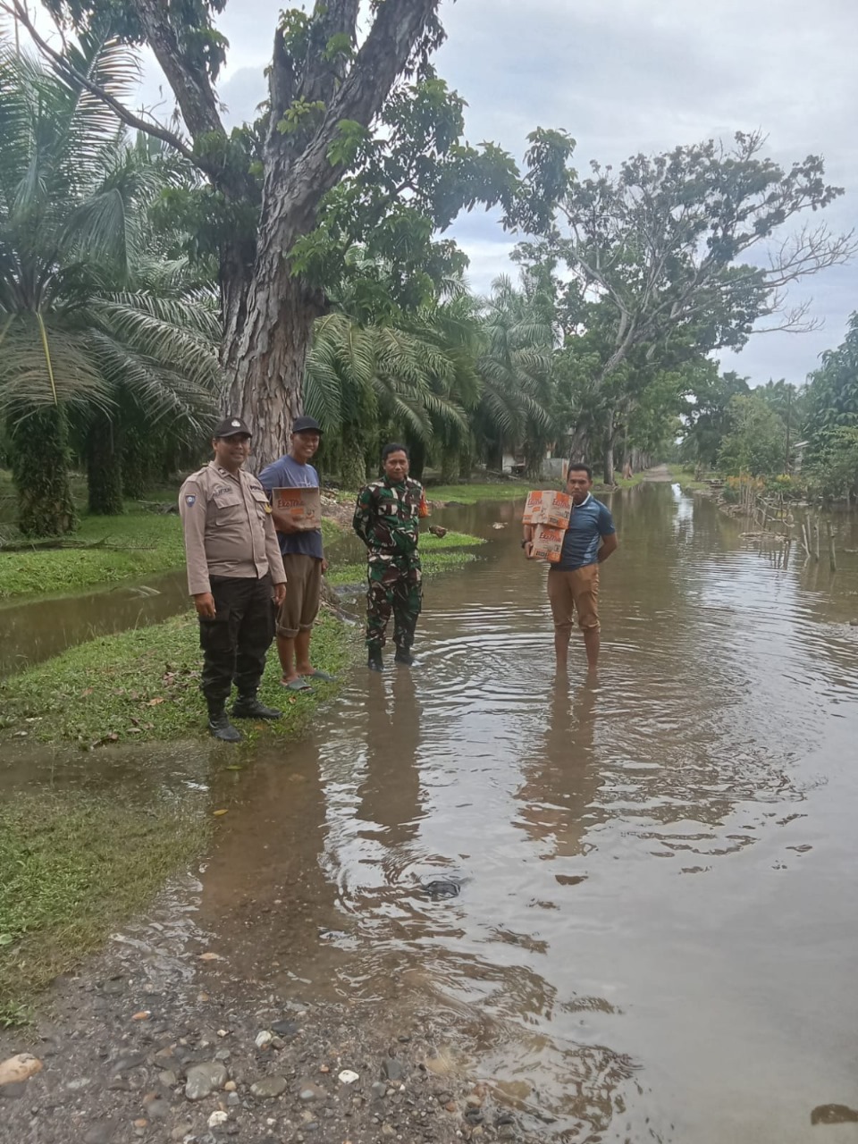 Bhabinkamtibmas Polsek Hinai Bersama Perangkat Desa Tamaran dan Babinsa Koramil Salurkan Bantuan kepada Warga Terdampak Banjir.