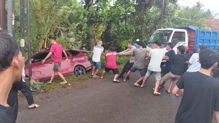 Kapolsek Wiradesa dan Warga Bantu Evakuasi Mobil yang Terperosok