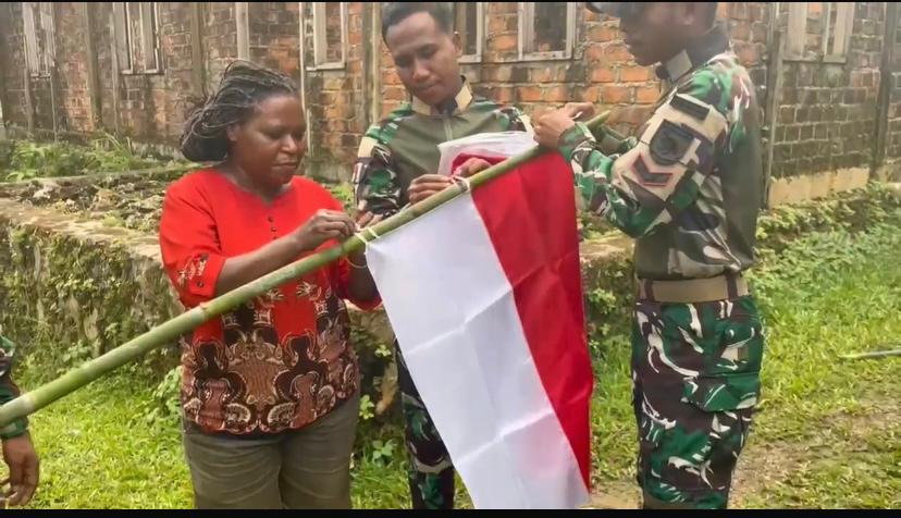 Satgas Yonif 763/SBA Menggandeng Warga Kampung Aisyo Mengibarkan Bendera Merah Putih   