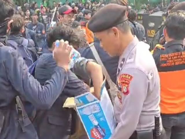 Polisi Bagikan Air Mineral kepada Massa Demo di Senayan   
