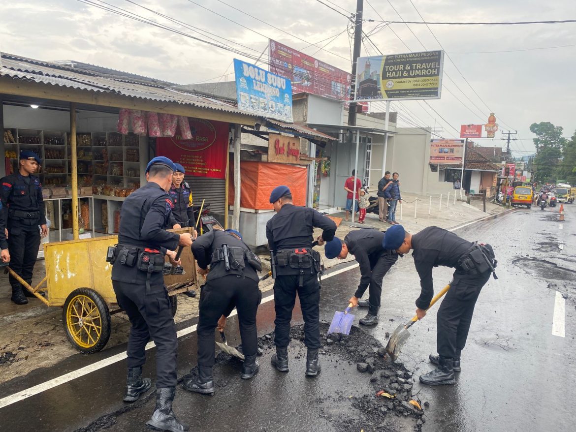Sat Brimob Polda Jabar Bersihkan Material Pasir dan Kerikil di Jalan Raya Tangkuban Perahu Pasca Hujan Deras   